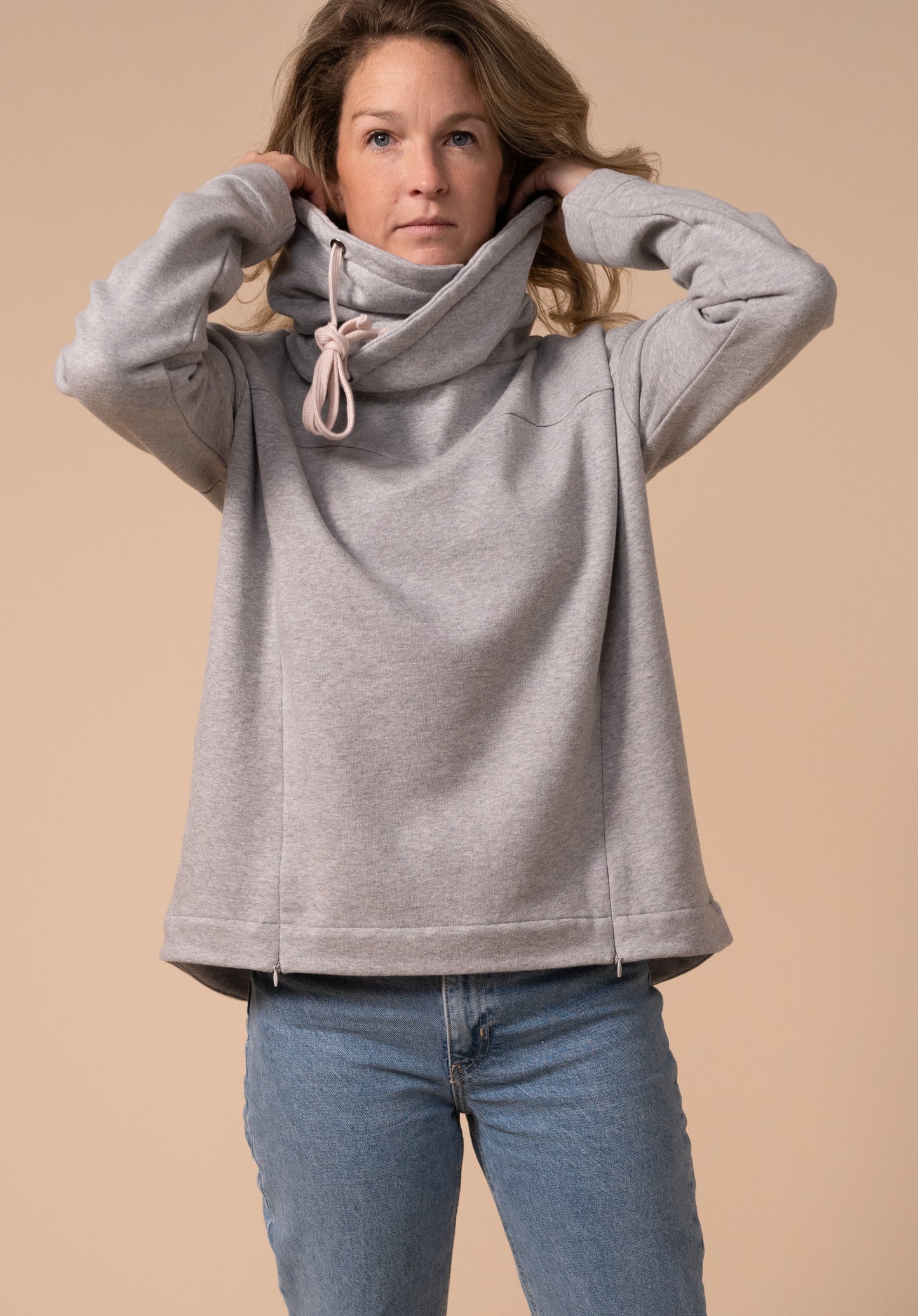 Model holds the neck to show the volume of the fabric around the neck in this nursing friendly jumper