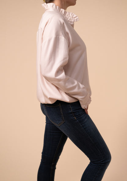 Side view of the ruffle nursing blouse tucked into a pair of skinny jeans for a smarter look