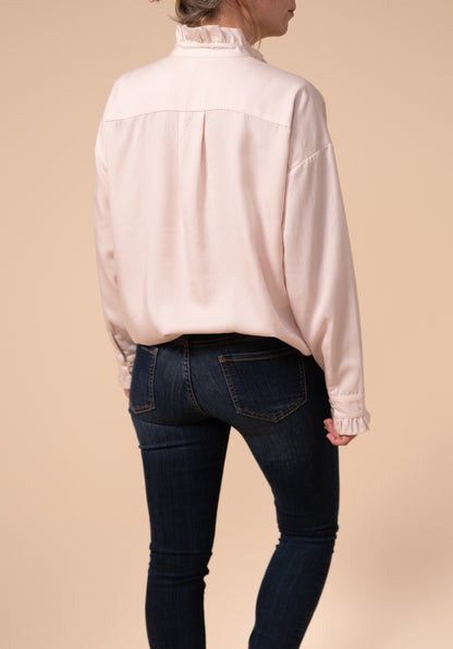 Back view of the Ruffle nursing blouse showing it tucked into a pair of skinny jeans for a smart casual look