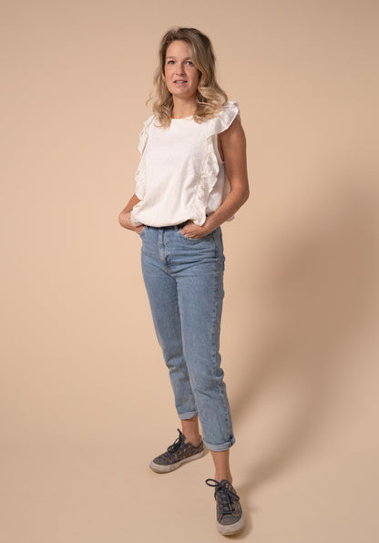 images showing breastfeeding friendly Broderie anglaise top in off white tucked into a pair of jeans